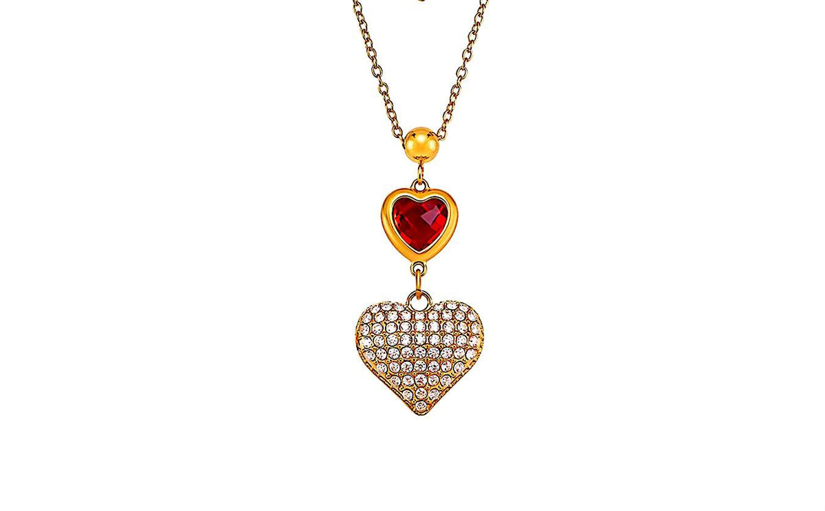 A gold-toned pendant necklace featuring a small red heart charm and a larger heart-shaped pendant paved with clear rhinestones